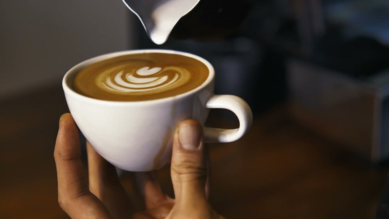 Latte art poured into a white cup
